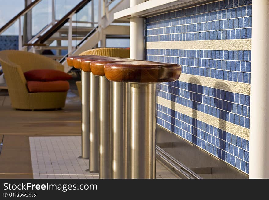 Nice chrome and wood barstools in front of a tile bar on a ship. Nice chrome and wood barstools in front of a tile bar on a ship