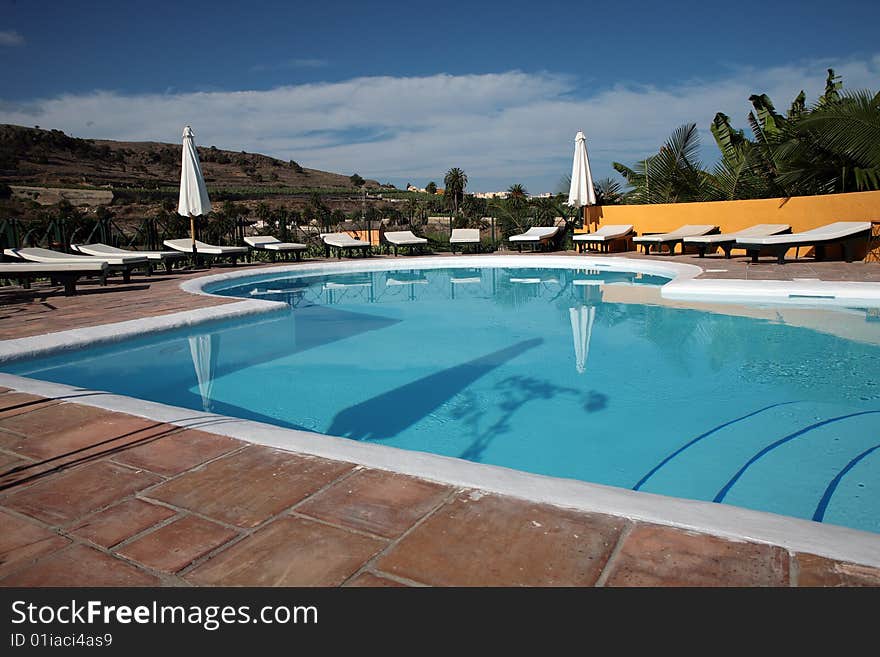 Beautiful swimming pool surrounded by chairs and plants