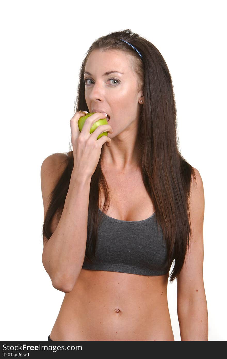 Fitness woman biting an apple isolated on white