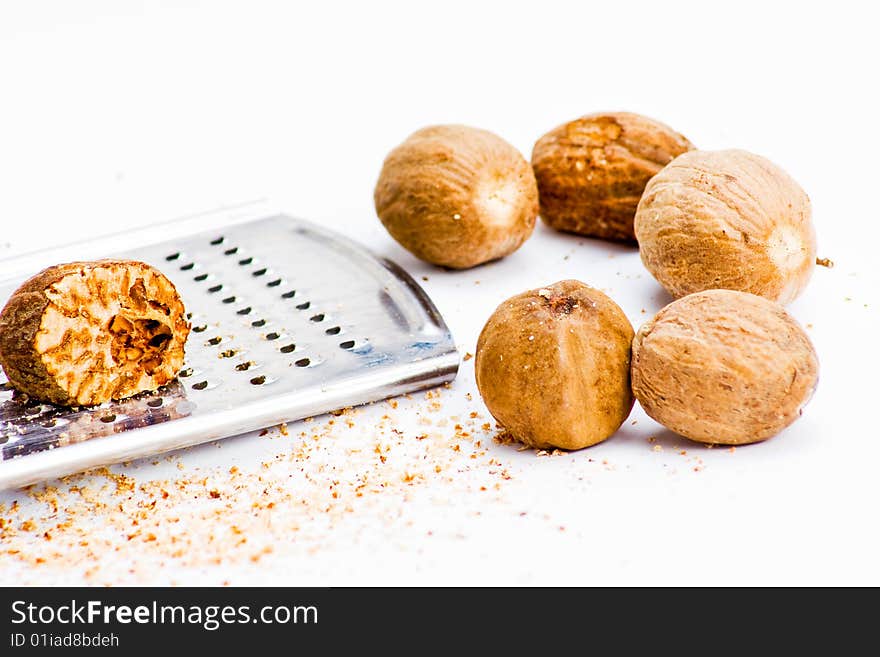 Several nutmegs with grater and fresh shavings. Several nutmegs with grater and fresh shavings