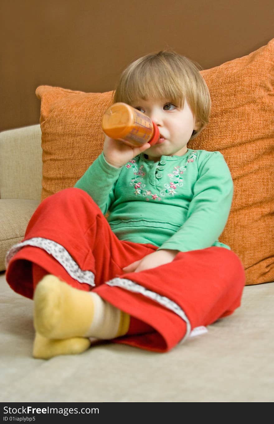 Sweet baby girl drinking on sofa. Sweet baby girl drinking on sofa