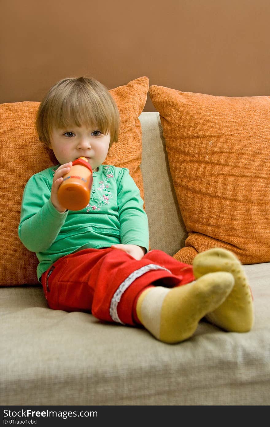 Sweet baby girl drinking on sofa. Sweet baby girl drinking on sofa