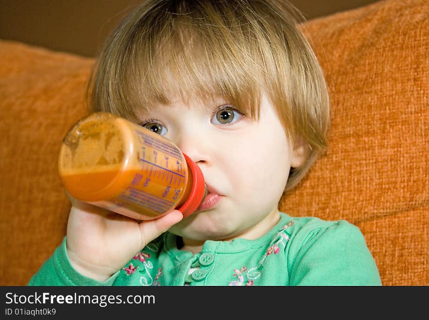 Sweet baby girl drinking on sofa. Sweet baby girl drinking on sofa