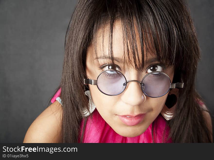 Close up portrait of a pretty brunette woman looking over her glasses. Close up portrait of a pretty brunette woman looking over her glasses