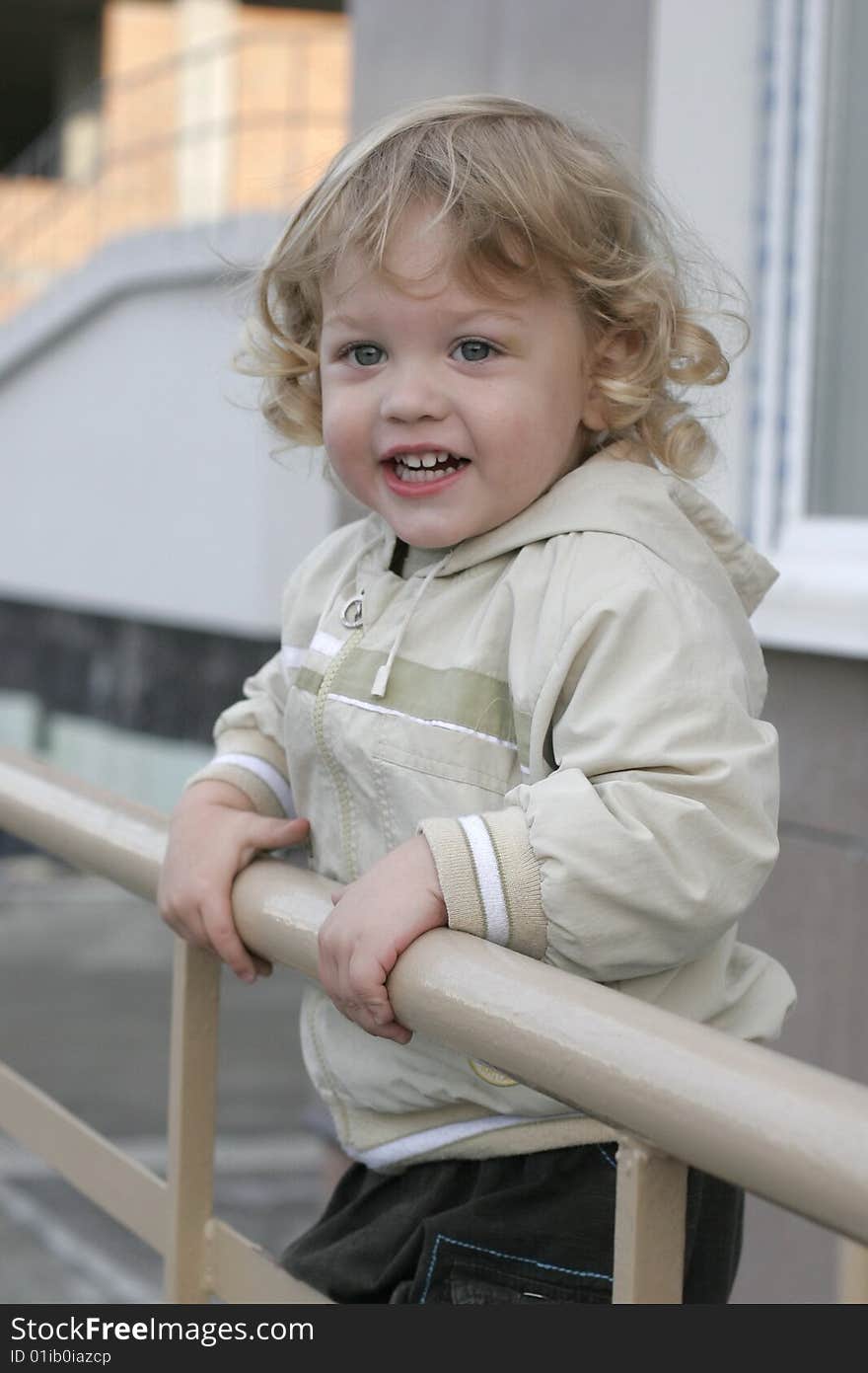 The boy is looking at the street. The boy is looking at the street