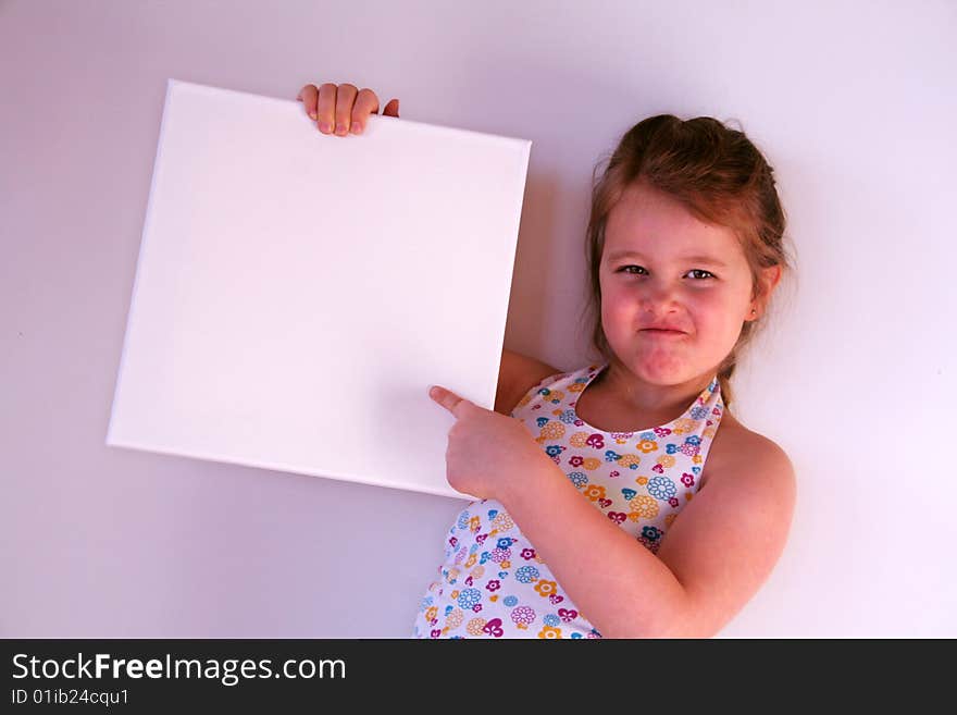 A girl is holding a white frame in her hands. A girl is holding a white frame in her hands