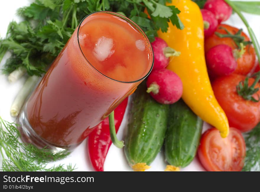 Fresh vegetables and glass of tomato juice on a white background