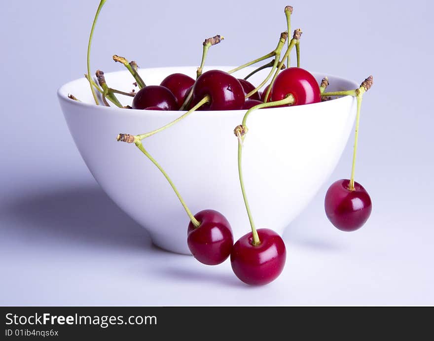 Big red cherries in bowl on white background