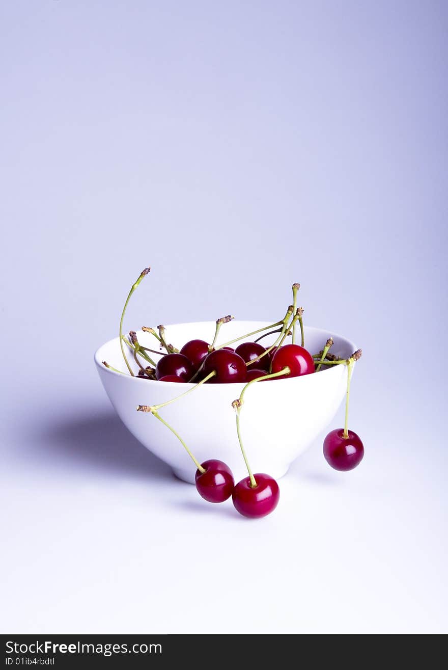 Big red cherries in bowl on white background