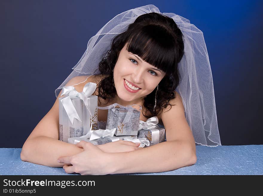 Studio portrait of a beautiful brunette bride with presents