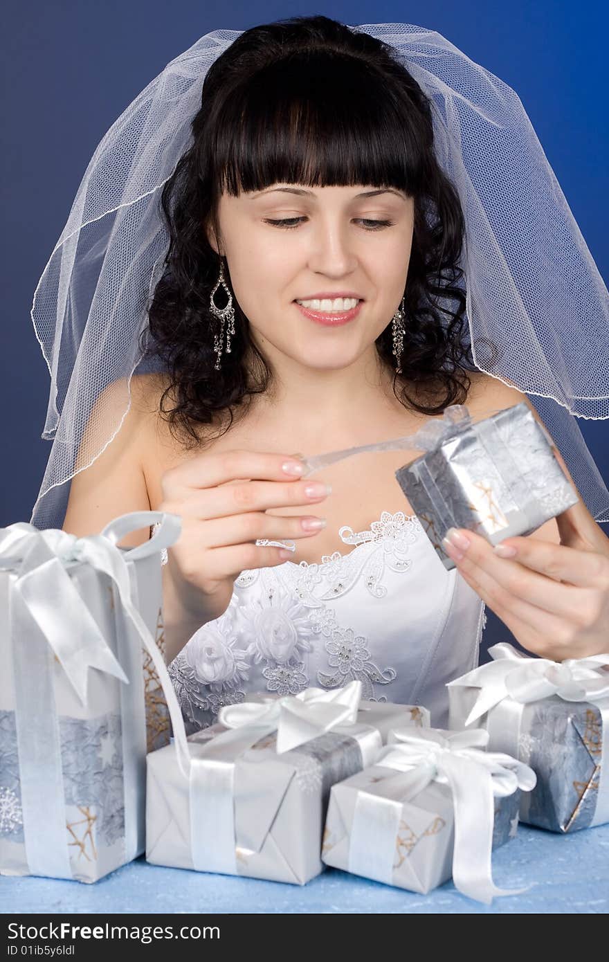 Studio portrait of a beautiful brunette bride with presents