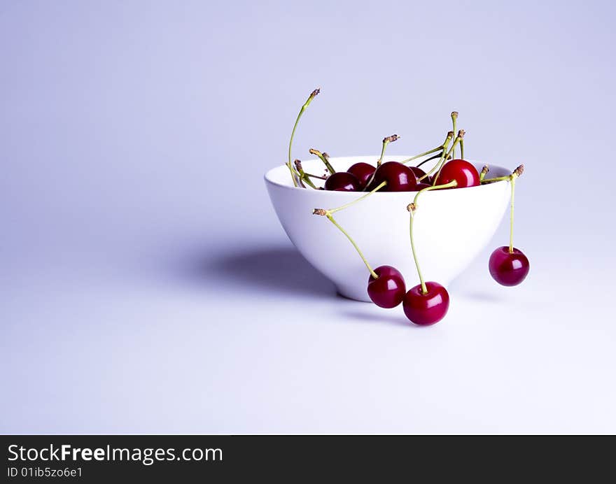 Big red cherries in bowl on white background