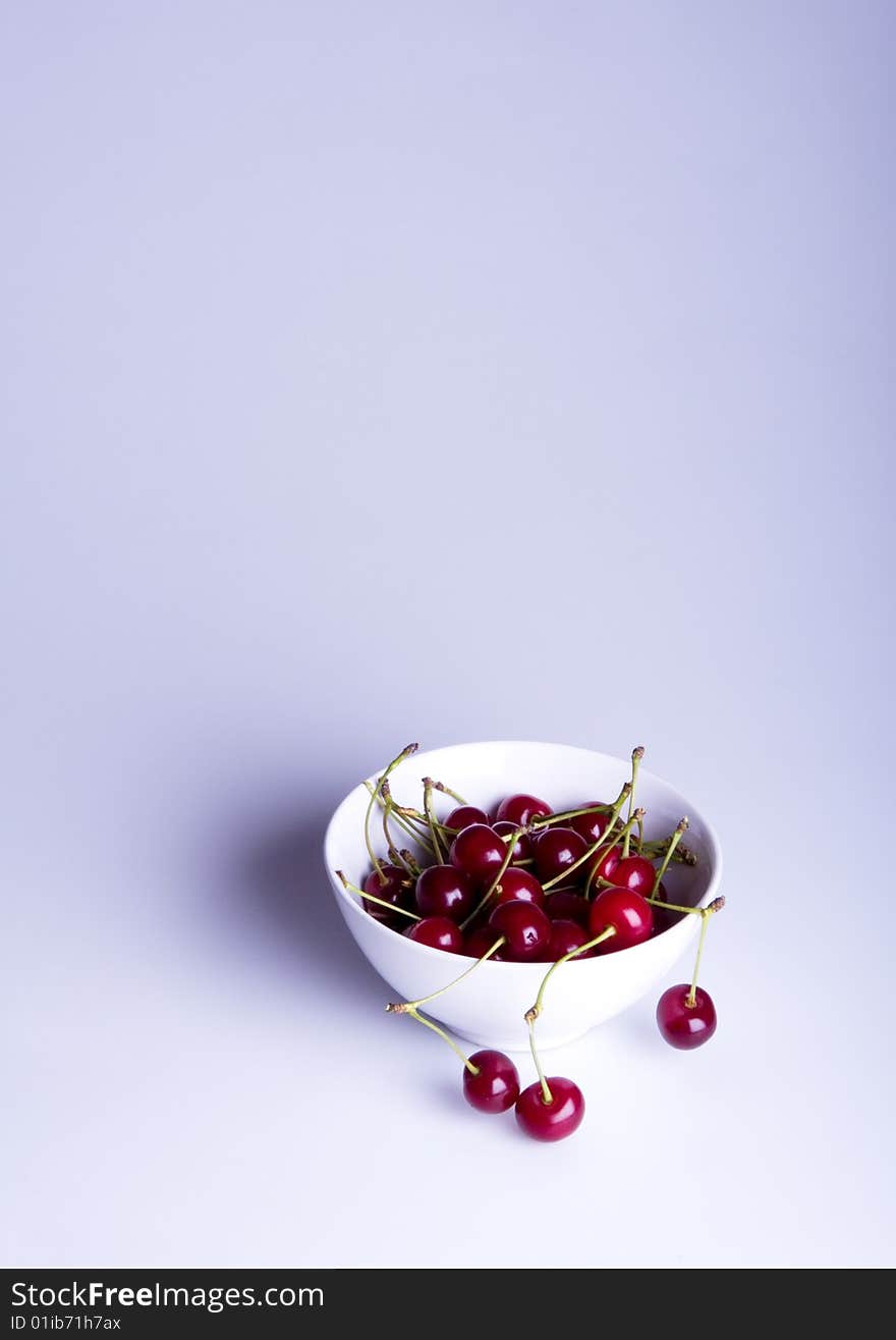 Big red cherries in bowl on white background