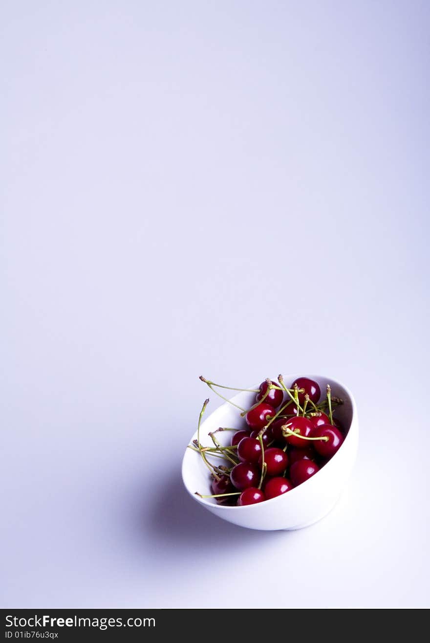 Big red cherries in bowl on white background