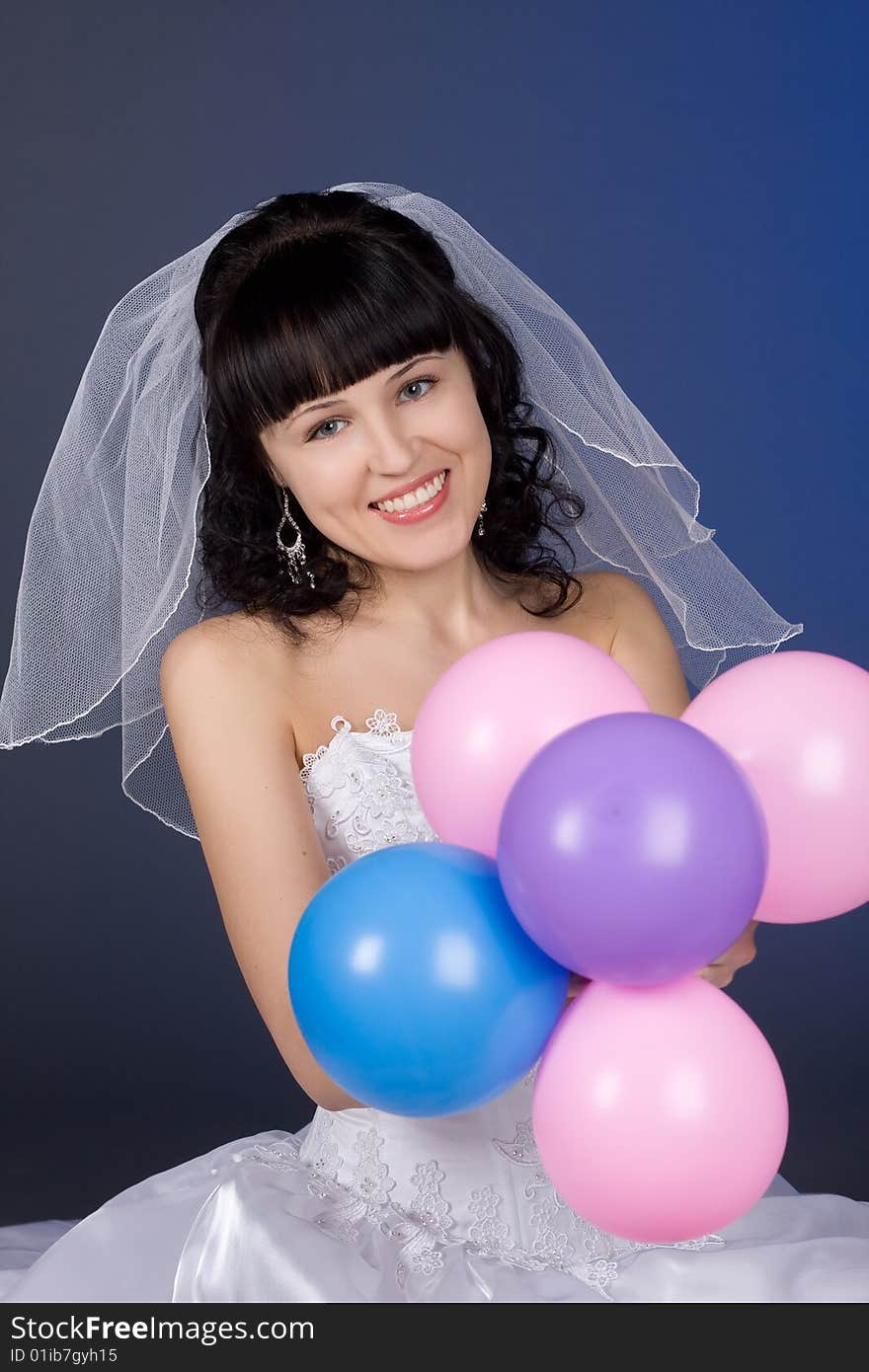 Studio portrait of a beautiful brunette bride with balloons