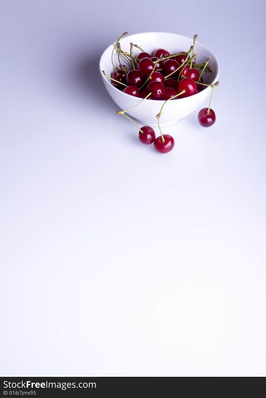 Big red cherries in bowl on white background