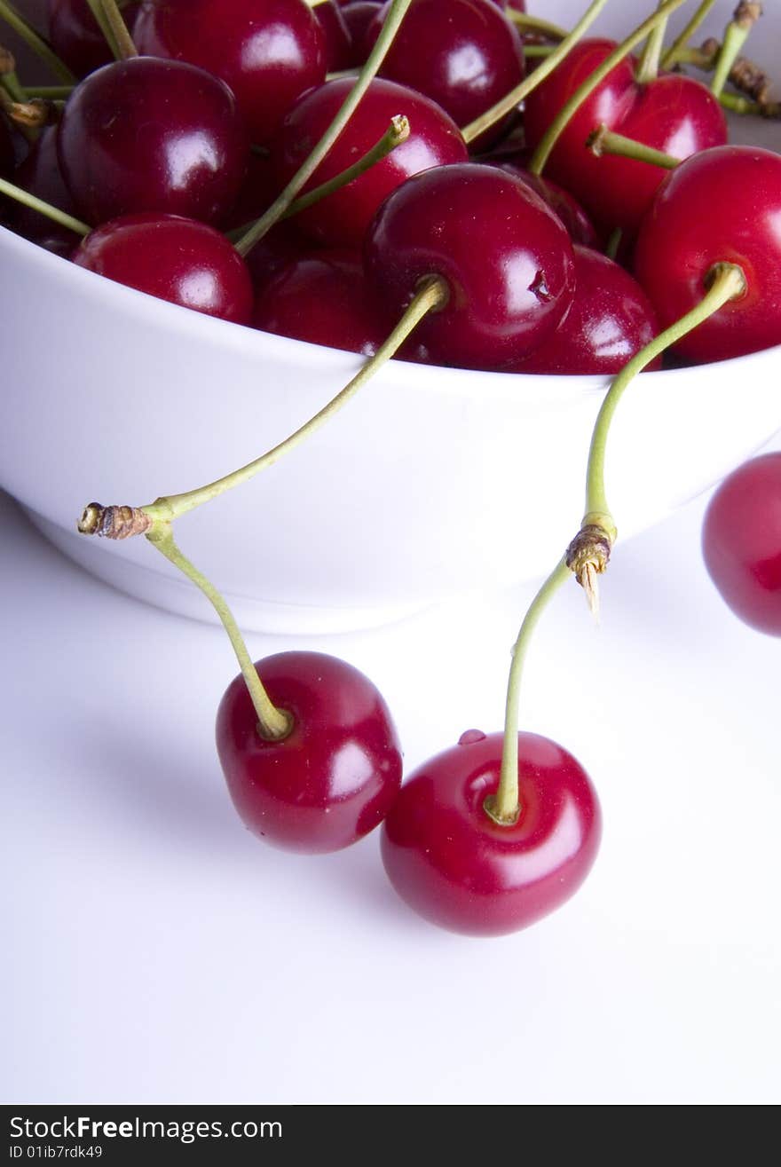 Big red cherries in bowl on white background