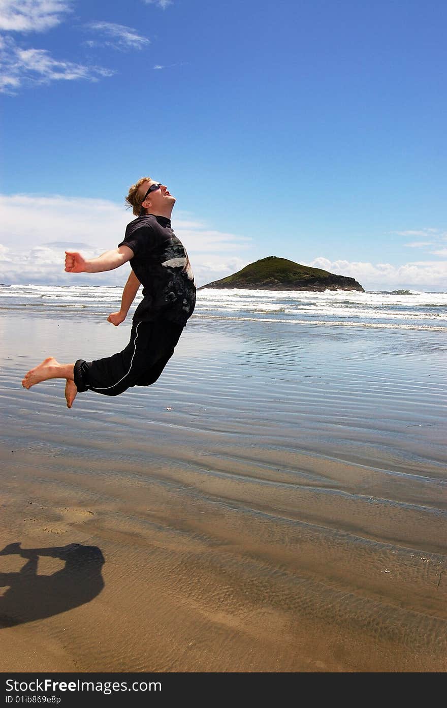 Man is jumping on a beautiful beach. Long Beach, Tofino, Canada. Man is jumping on a beautiful beach. Long Beach, Tofino, Canada.