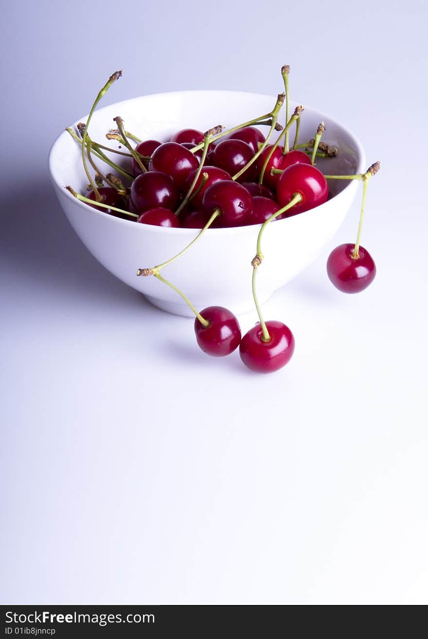 Big red cherries in bowl on white background