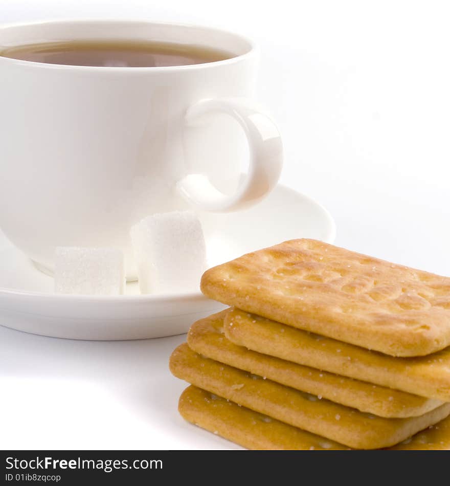 Cup of tea, sugar and cookies closeup on white