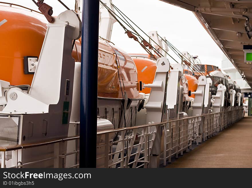 Lifeboats on a cruise ship along a walkway. Lifeboats on a cruise ship along a walkway