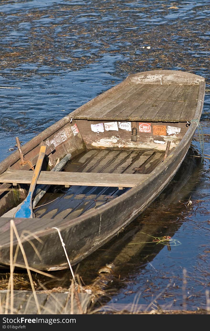 A boat which is frozen in the lake with a meditative beautiful mood in a romantic winter landscape. A boat which is frozen in the lake with a meditative beautiful mood in a romantic winter landscape