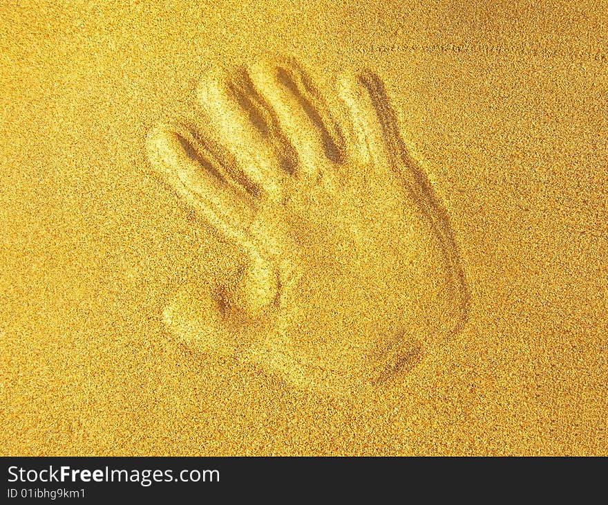 Hand print on beach sand