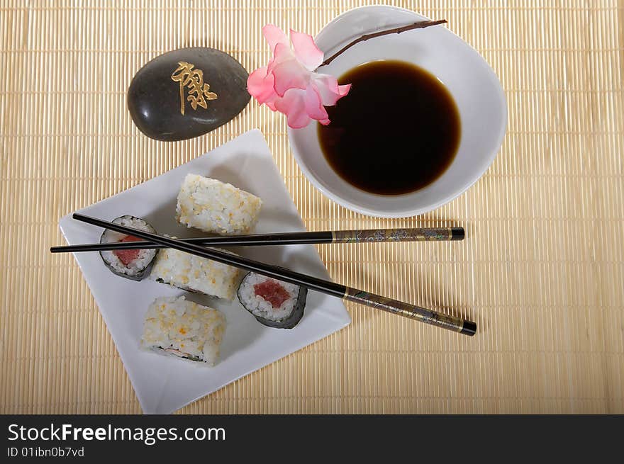 Sushi plate with chopsticks and pink flower