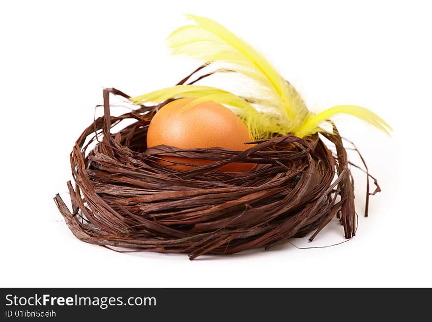 Egg in the nest with yellow feathers, isolated on white. Egg in the nest with yellow feathers, isolated on white