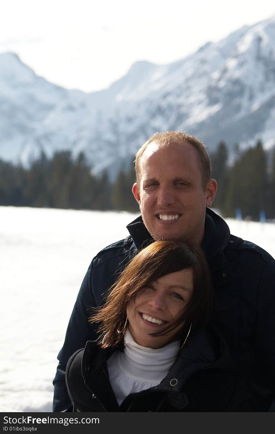 A young couple outdoor in a winter setting. The couple is hugging each other. A young couple outdoor in a winter setting. The couple is hugging each other.