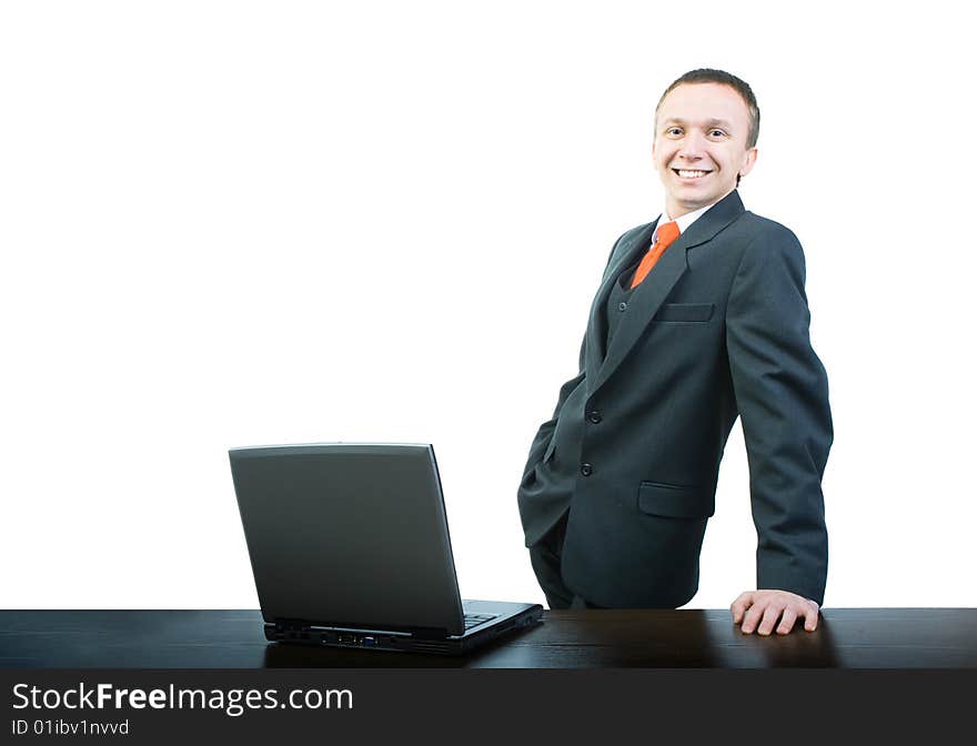 A young and happy businessman standing at a desk, propped up by hand. A young and happy businessman standing at a desk, propped up by hand.