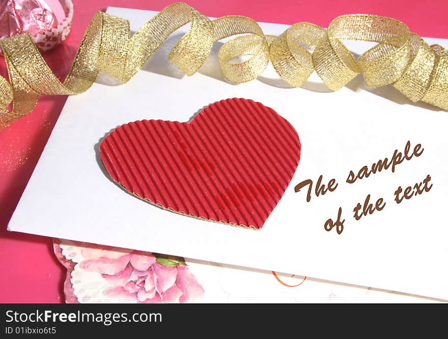 Background with cardboard heart of red color and a gold tape.