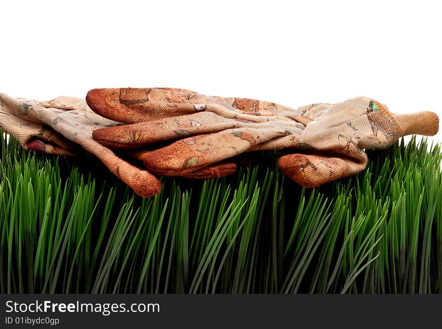 A horizontal view of old worn workgloves on green grass