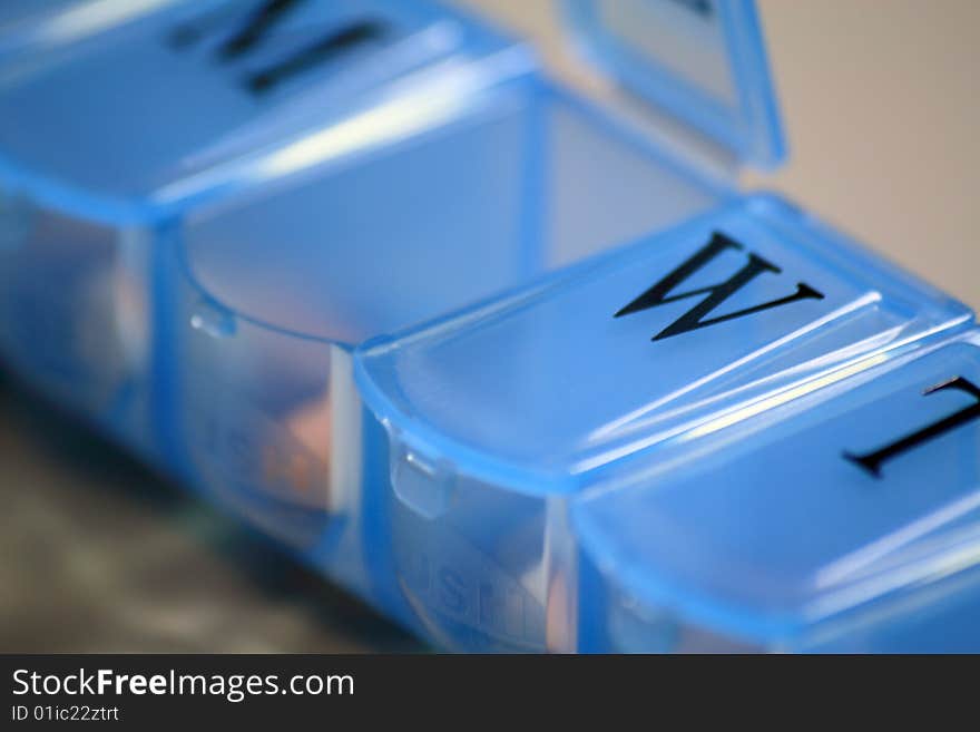 Closeup of an open medication dispenser with daily reminders. Closeup of an open medication dispenser with daily reminders.