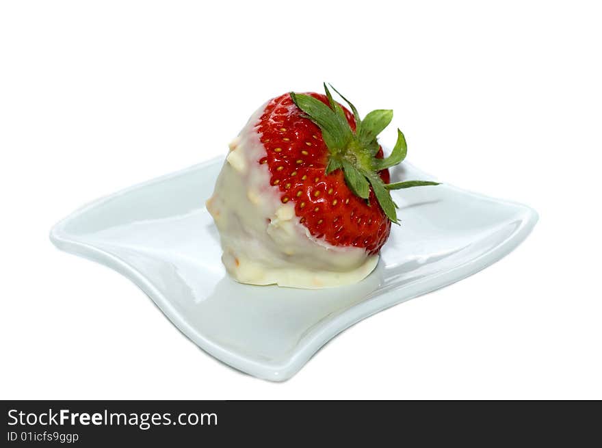 Strawberry dipped in white chocolate and nuts on a tiny plate, white background, studio shot