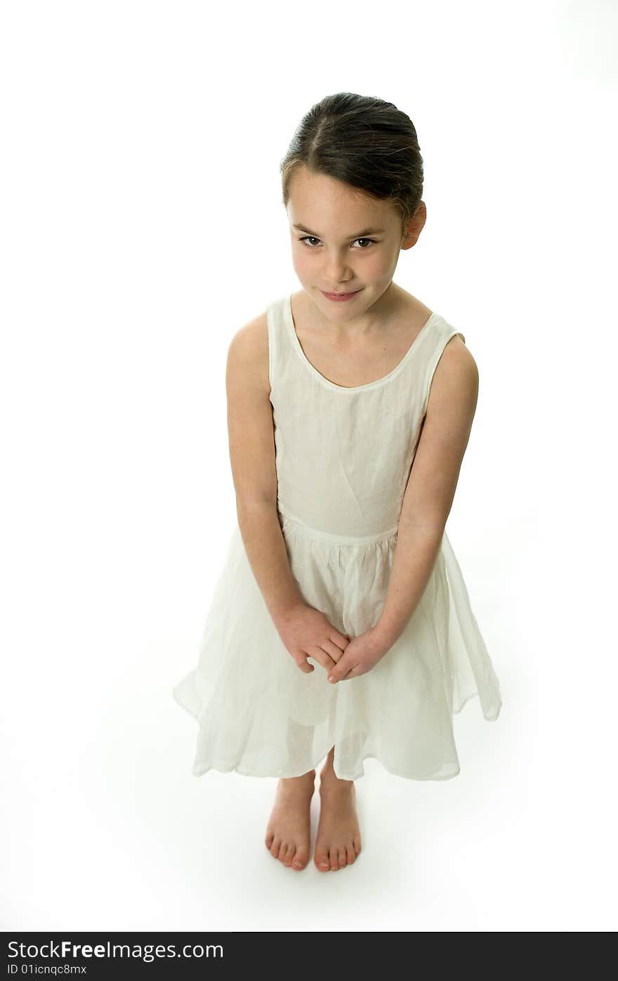 Little girl smiling confident in camera, isolated on white background. Showing an elegant white dress. Little girl smiling confident in camera, isolated on white background. Showing an elegant white dress.