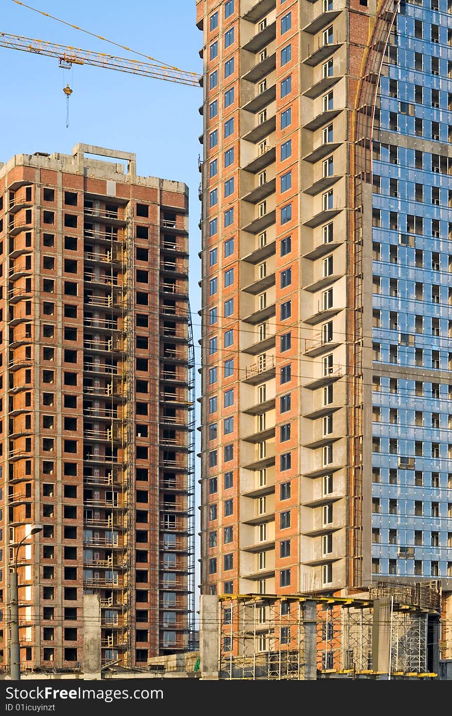 Two high-rise buildings under construction on a blue sky background