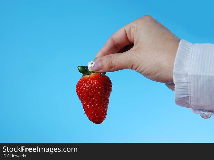 Strawberry in woamn's hand on blue background. Strawberry in woamn's hand on blue background