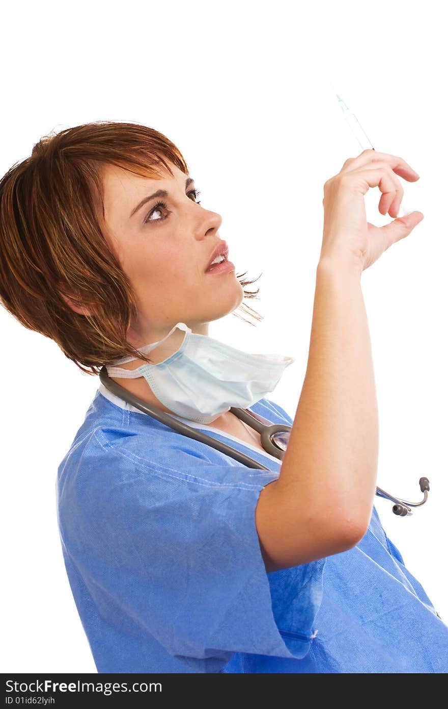 Attractive young female Caucasian doctor holding a filled syringe and checking for air bubbles. Attractive young female Caucasian doctor holding a filled syringe and checking for air bubbles