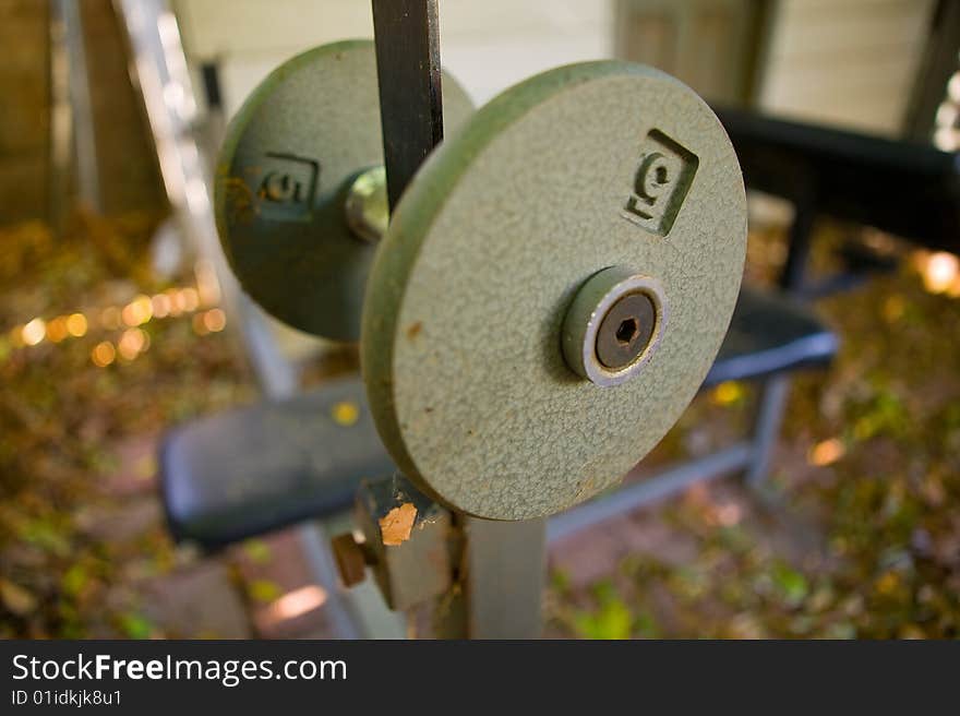 Dumbbell sitting on workout bench, being unused as usual.