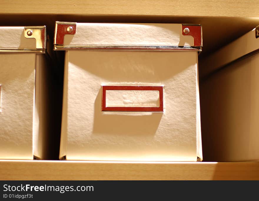 White papery boxes  on wooden  bookshelf