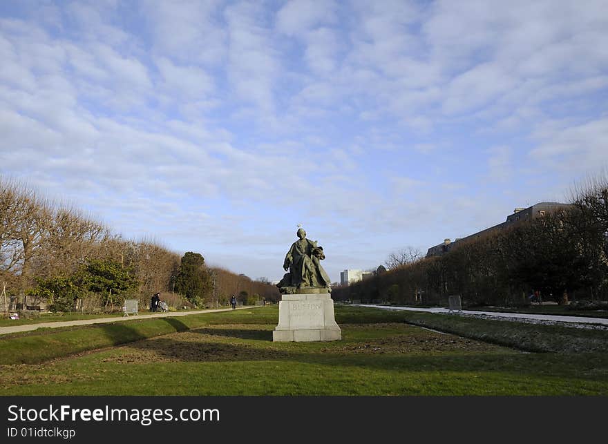 Meadow with statue and cloudy sky