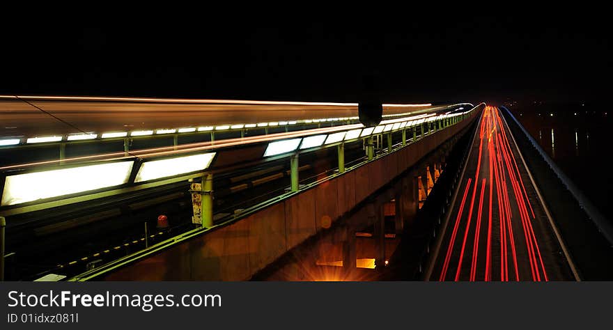 Subway-motor bridge at night with motion traces of cars and train. Subway-motor bridge at night with motion traces of cars and train