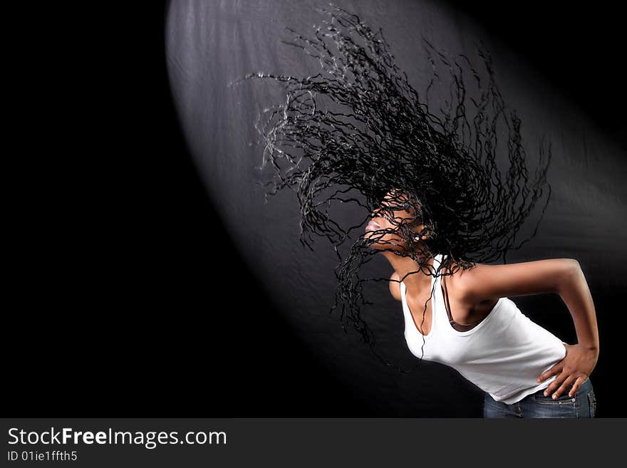 Wind - lovely young afro-american woman with long flapping hairs against black background