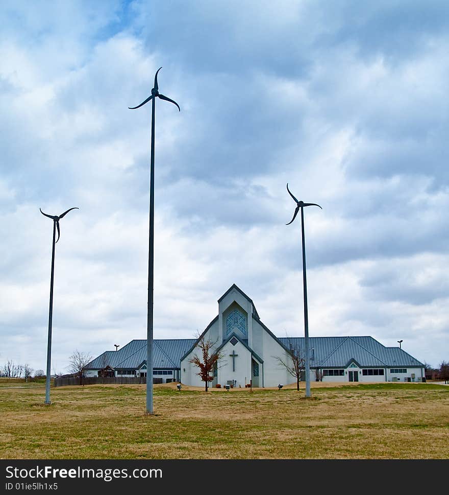 Three wind turbines in front of a church