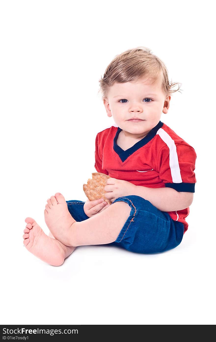 Little baby sits with cookies in hands on white background