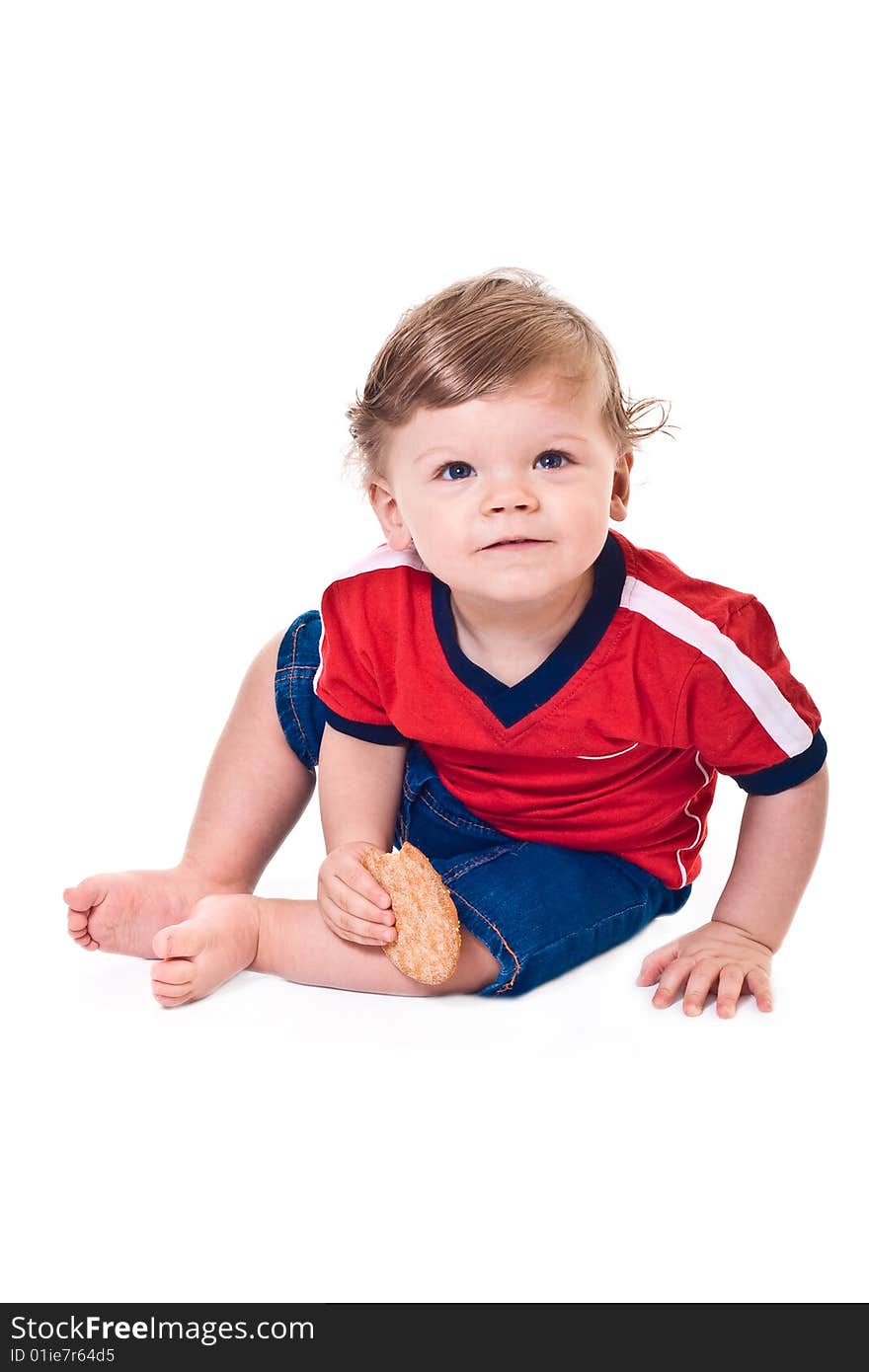 Curious baby crawls with cookies in hand on white background