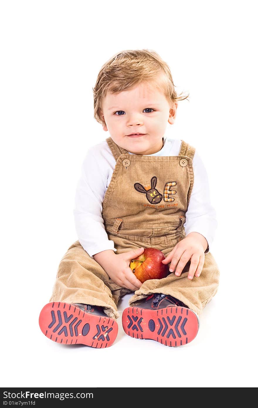 Sitting little boy holds on apple on white background