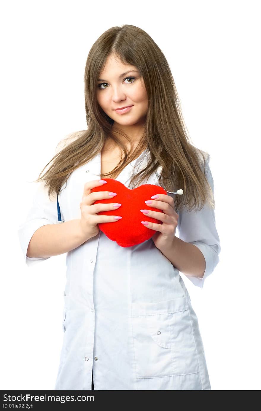 Beautiful young cardiologist with a heart shaped pillow in her hands