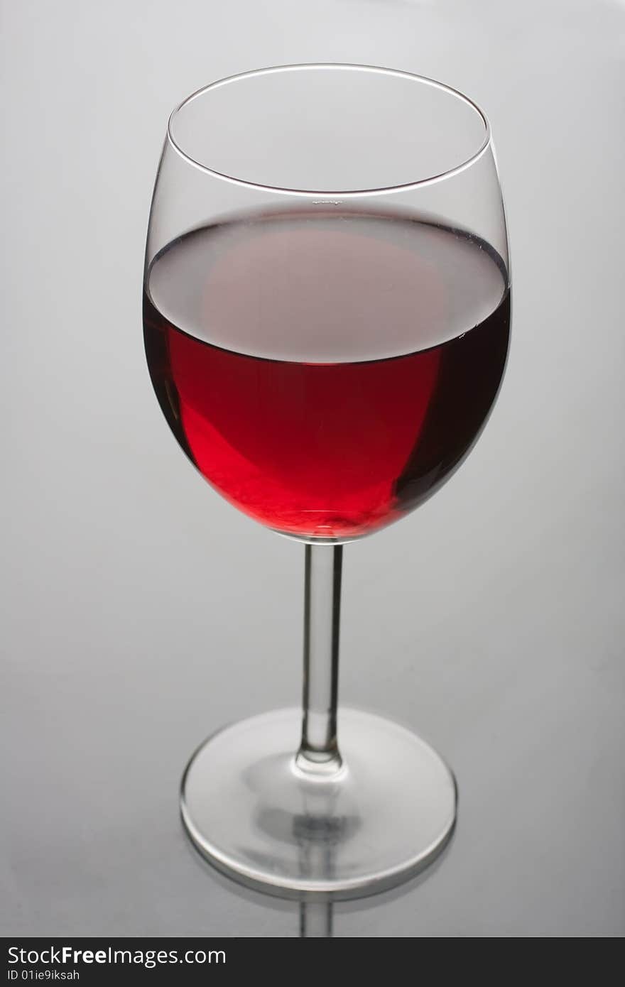 Glass of red wine on glass background